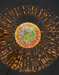 A sphere of rod like fibers radiating energy in all directions on a dark background.