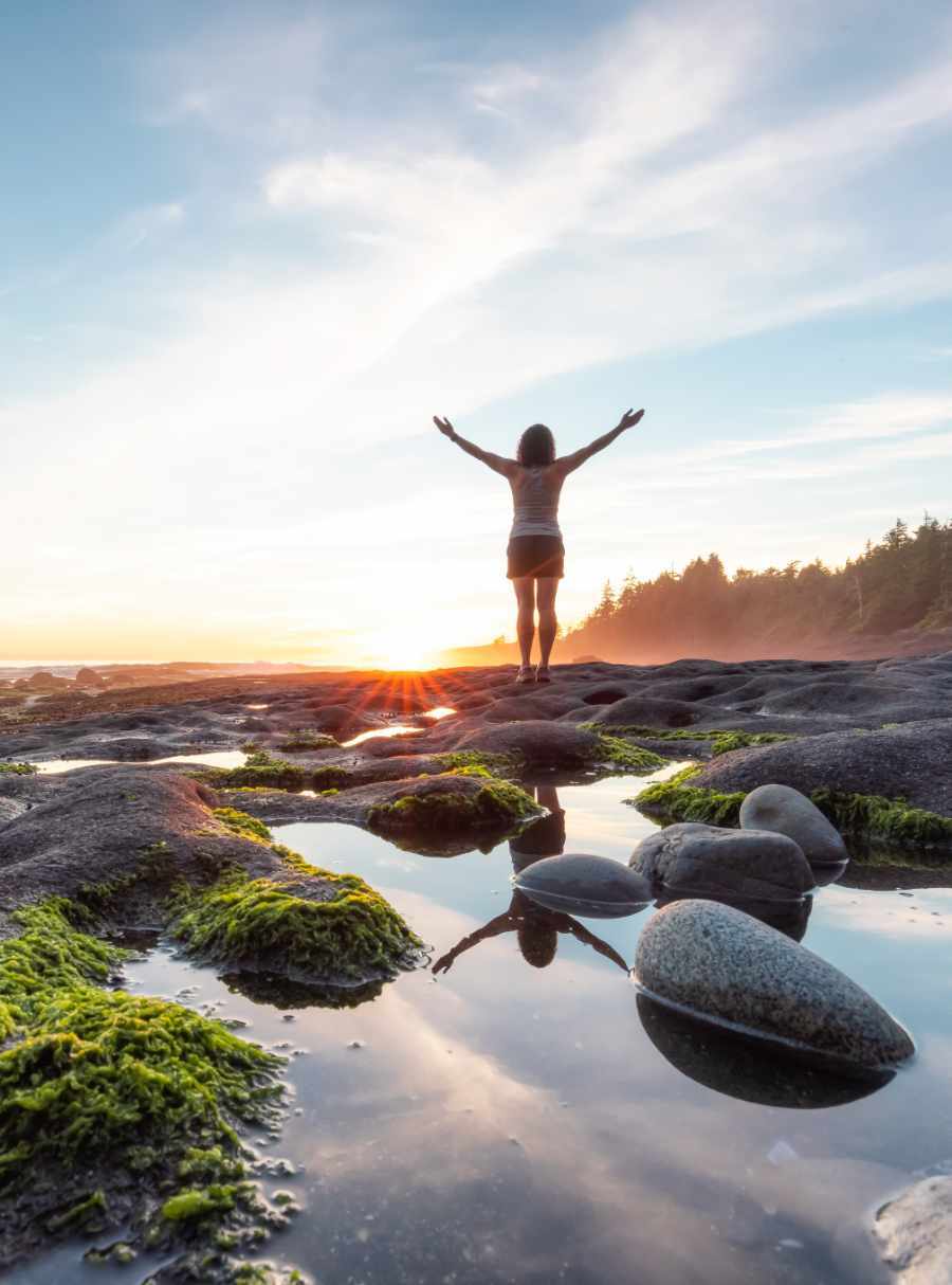 Adventurous Woman Hiking at Botanical Beach on the West Coast of Pacific Ocean. Summer Sunny Sunset. Canadian Nature Landscape Background. Port Renfrew near Victoria, Vancouver Island, BC, Canada.