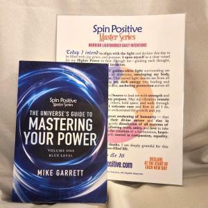 A copy of Volume #1 of the Spin Positive Master Series, the Blue Level sits in front of a laminated heavy-duty Master Series Daily Intention Set